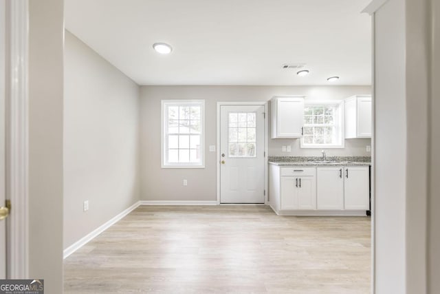 kitchen featuring sink, light hardwood / wood-style floors, and white cabinets