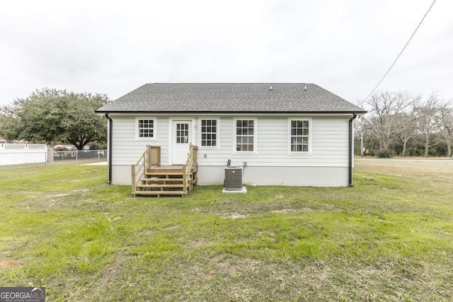 back of property with a yard and central air condition unit