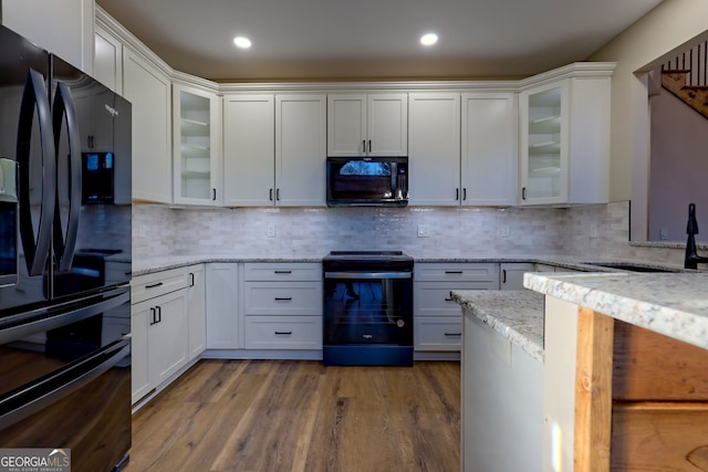 kitchen with white cabinets, sink, and black appliances