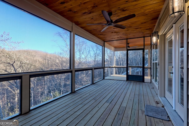 unfurnished sunroom featuring wooden ceiling and ceiling fan