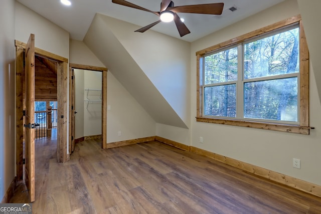 additional living space with hardwood / wood-style flooring and ceiling fan