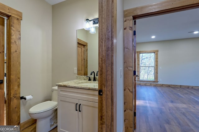 bathroom featuring vanity, hardwood / wood-style flooring, and toilet