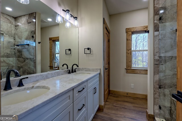 bathroom with vanity, tiled shower, and hardwood / wood-style floors