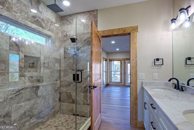 bathroom featuring wood-type flooring, a wealth of natural light, vanity, and walk in shower