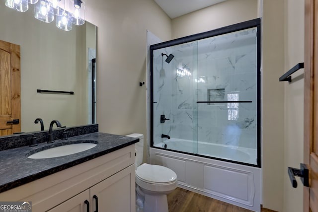 full bathroom featuring vanity, combined bath / shower with glass door, wood-type flooring, and toilet