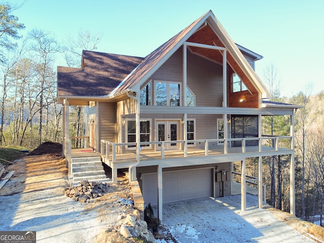 rear view of property with a garage, a sunroom, and french doors