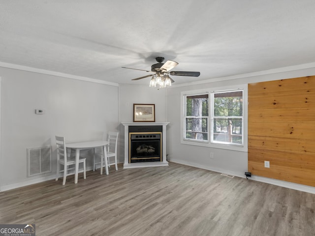 unfurnished living room featuring ornamental molding, light hardwood / wood-style floors, and ceiling fan