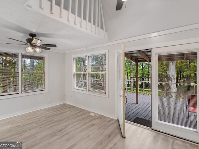 interior space featuring light hardwood / wood-style flooring, ceiling fan, and a high ceiling