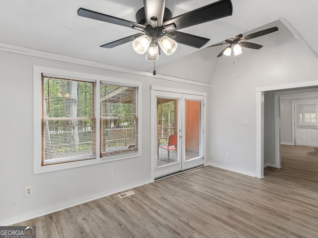 spare room with vaulted ceiling, light hardwood / wood-style floors, french doors, and ceiling fan