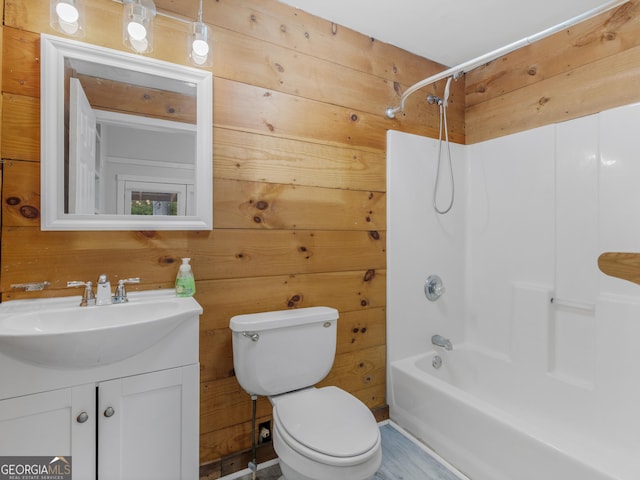 full bathroom with vanity, wooden walls, tub / shower combination, and toilet