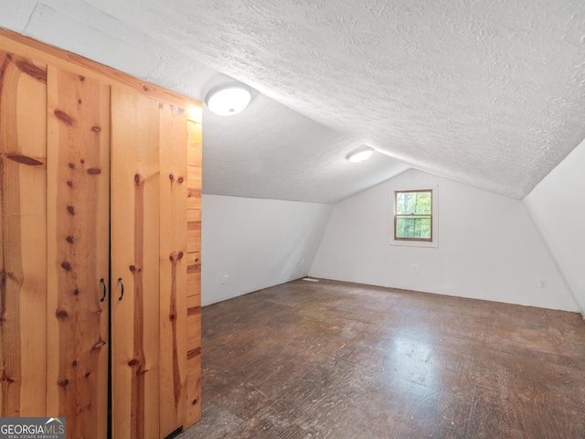 additional living space with lofted ceiling and a textured ceiling