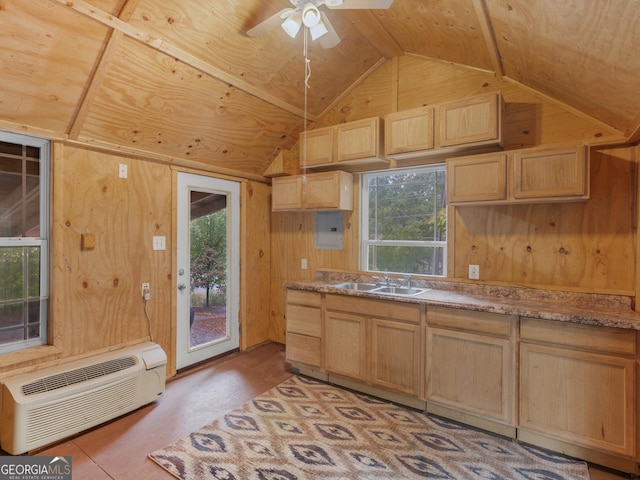 kitchen with lofted ceiling, sink, plenty of natural light, a wall mounted AC, and wood walls