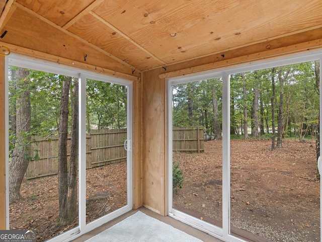 unfurnished sunroom featuring vaulted ceiling and wooden ceiling