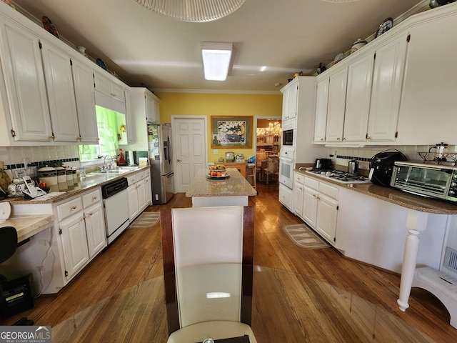 kitchen featuring white cabinetry, white appliances, and a kitchen island