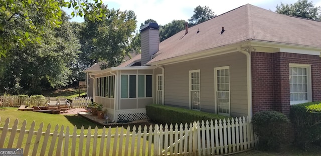 back of property featuring a yard and a sunroom