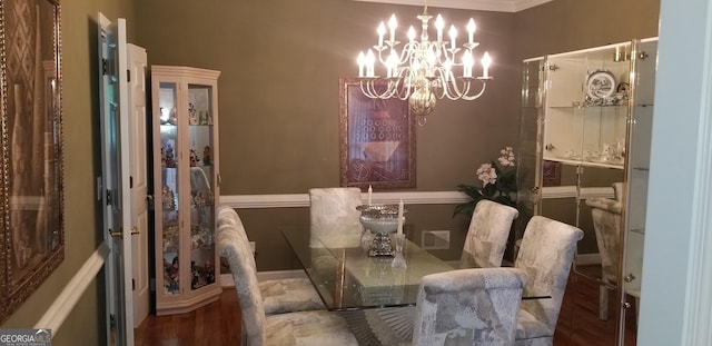 dining space featuring dark wood-type flooring and a chandelier