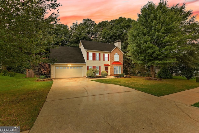 colonial-style house featuring a garage and a lawn