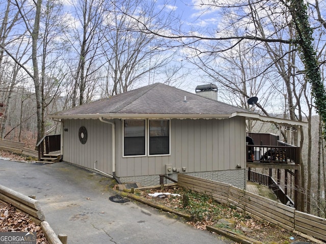 view of property exterior with a chimney and roof with shingles