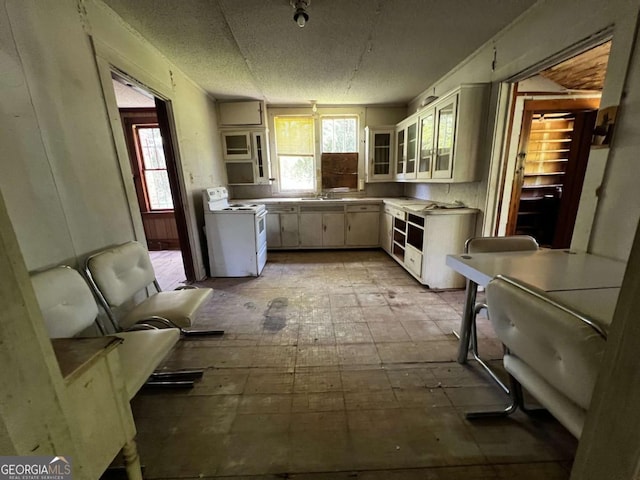 kitchen featuring white cabinetry and white range oven