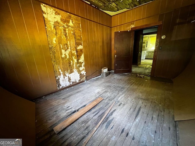 empty room with dark hardwood / wood-style flooring and wood walls