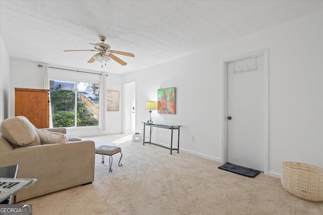 sitting room with light carpet, ceiling fan, and a textured ceiling