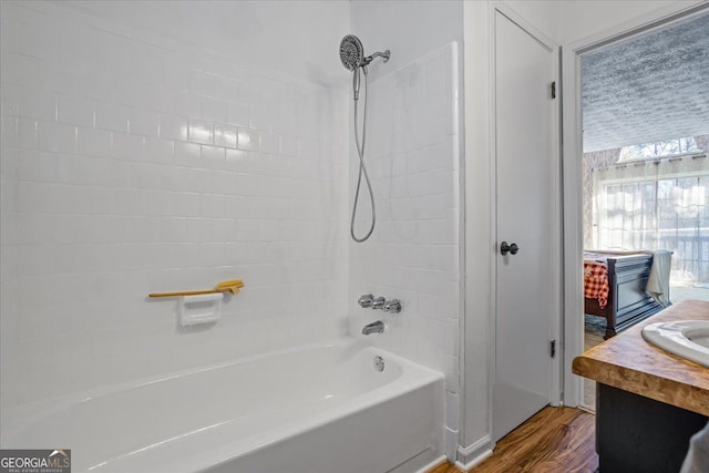 bathroom with vanity, hardwood / wood-style floors, and tiled shower / bath