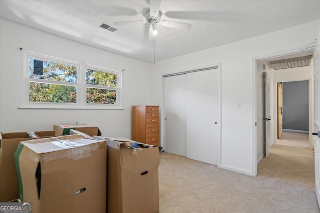 carpeted home office featuring ceiling fan and a textured ceiling