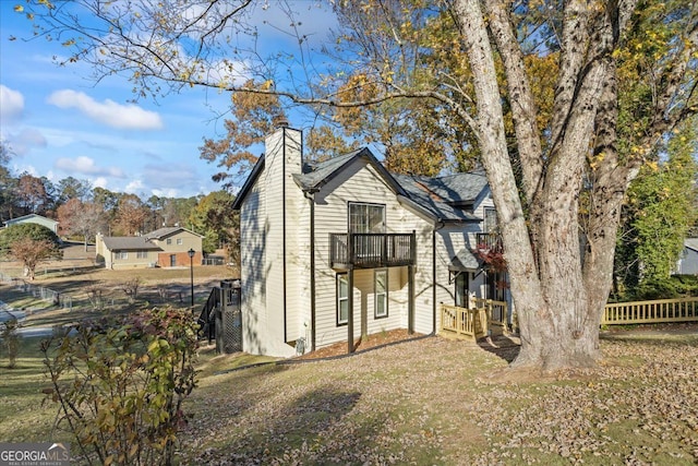 view of front facade featuring a balcony and a front yard