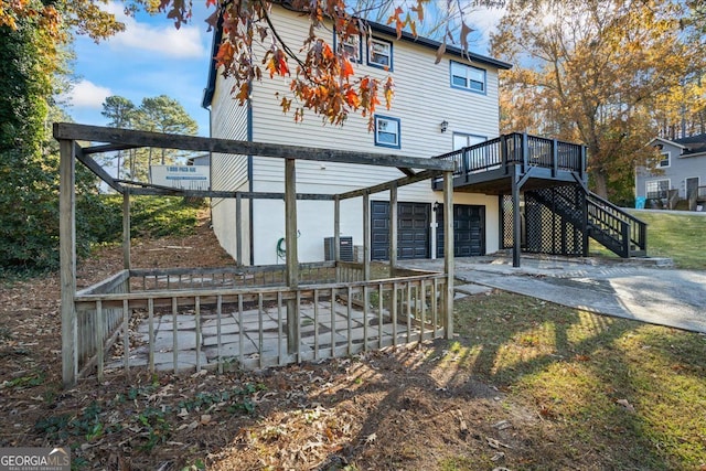 rear view of house with a garage and a wooden deck