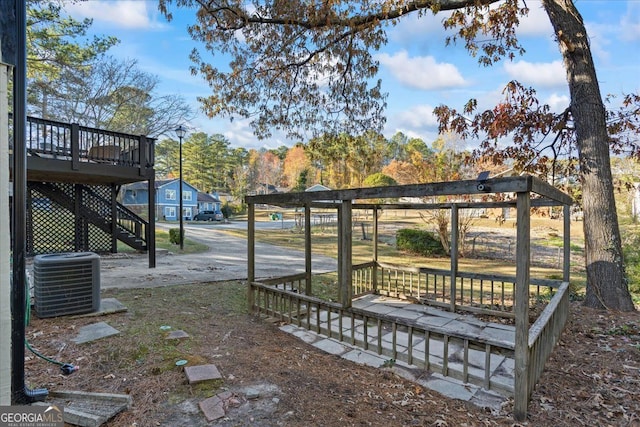 view of yard with a wooden deck and central air condition unit