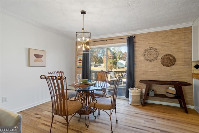 dining room with a notable chandelier, crown molding, and light hardwood / wood-style floors