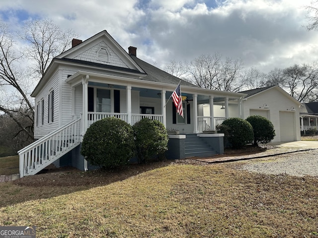 view of front of home featuring a porch, a garage, and a front yard