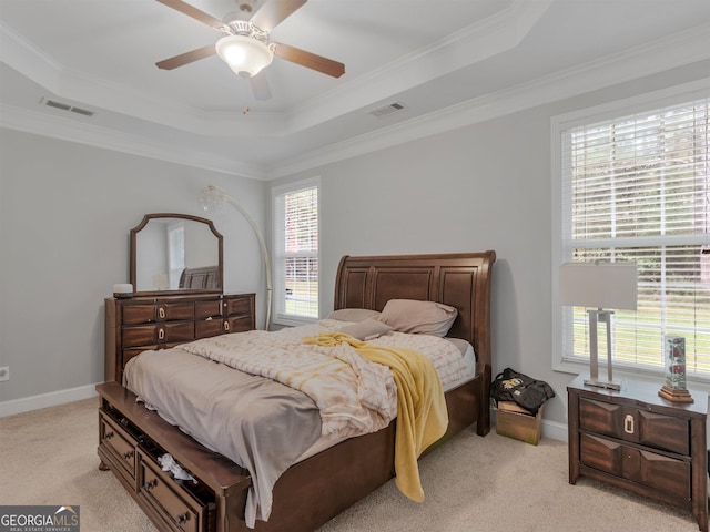 carpeted bedroom featuring ornamental molding, ceiling fan, and a tray ceiling