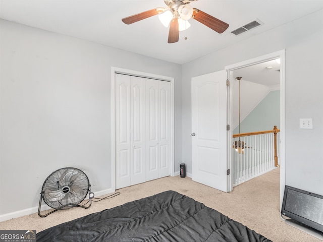 carpeted bedroom featuring ceiling fan and a closet