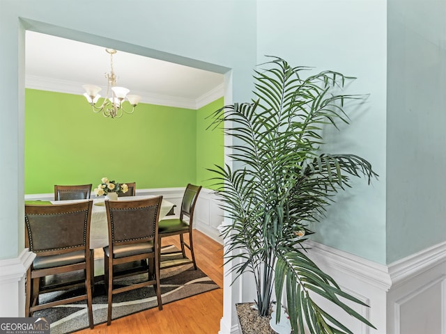 dining room with ornamental molding, a chandelier, and wood-type flooring