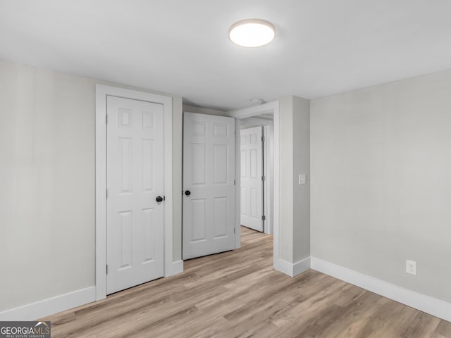 unfurnished bedroom featuring a closet and light hardwood / wood-style flooring