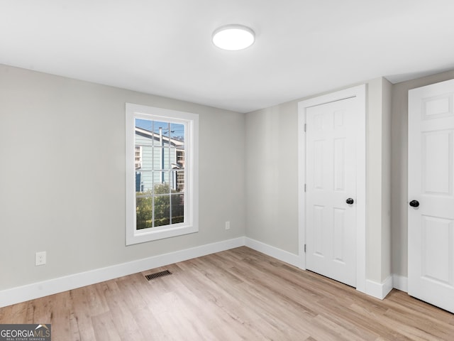 unfurnished bedroom featuring light hardwood / wood-style floors and a closet