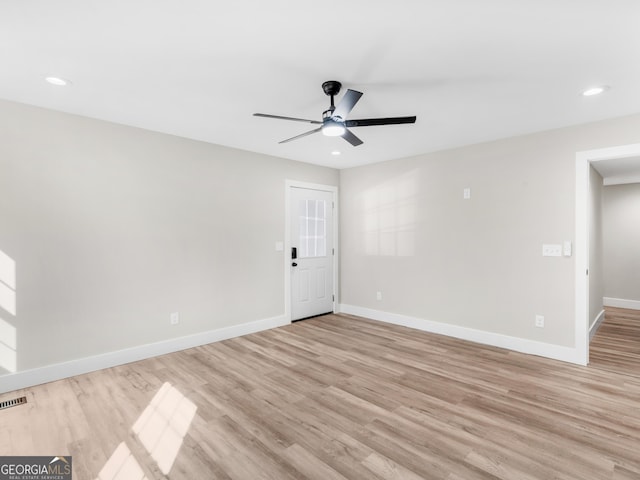 empty room with ceiling fan and light hardwood / wood-style flooring