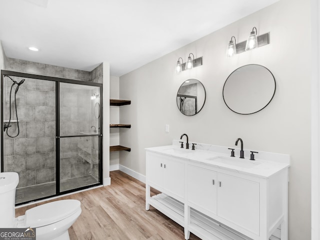 bathroom featuring vanity, an enclosed shower, wood-type flooring, and toilet