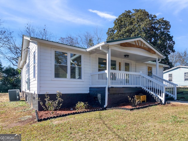 view of front facade featuring a porch, central AC unit, and a front lawn