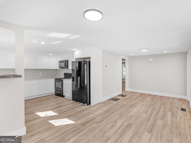 kitchen with white cabinetry, light hardwood / wood-style floors, and black appliances