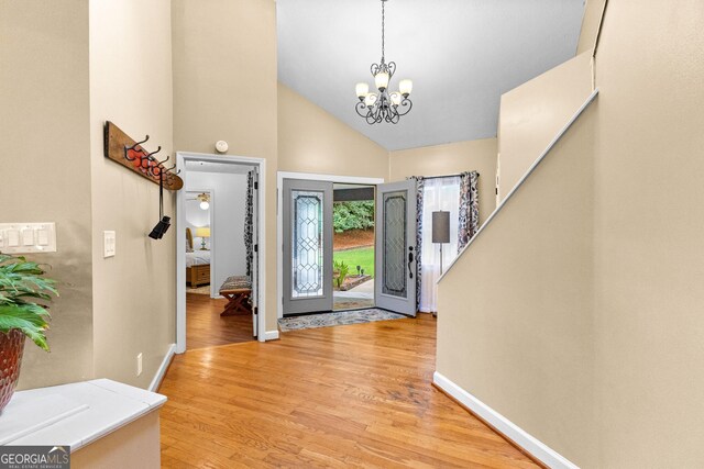 entryway featuring high vaulted ceiling, a chandelier, and light hardwood / wood-style flooring