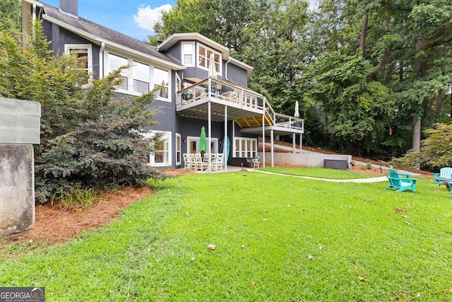 back of house featuring a lawn and a deck