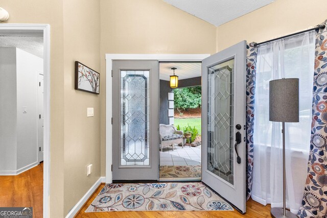 foyer with lofted ceiling and hardwood / wood-style flooring