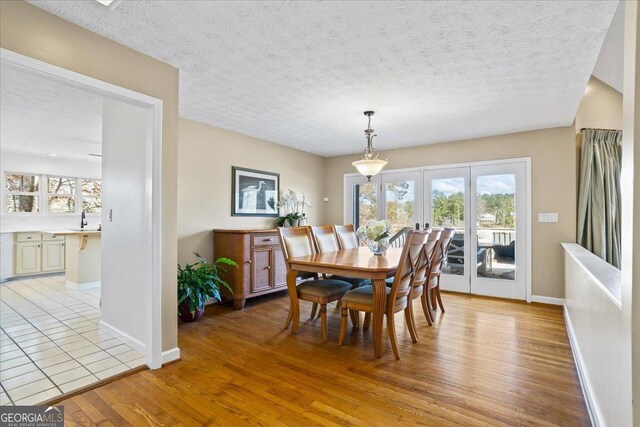 dining space featuring a textured ceiling and light wood-type flooring