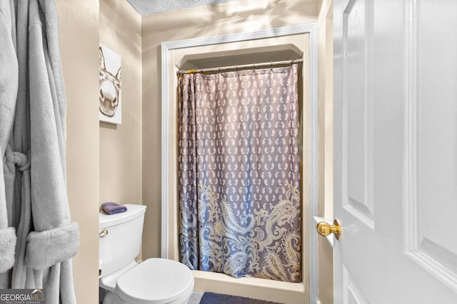 bathroom with curtained shower and toilet