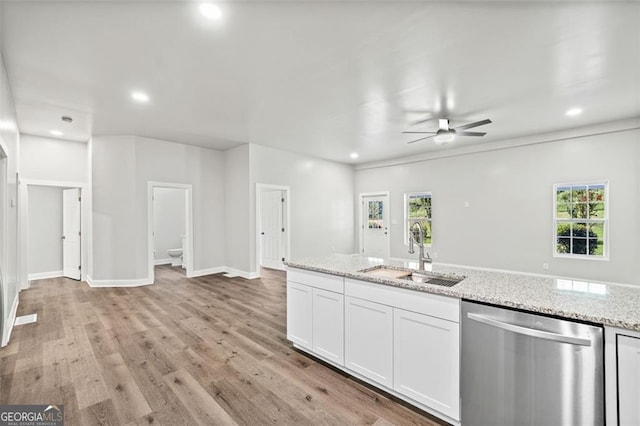 kitchen with dishwasher, sink, white cabinets, light stone counters, and plenty of natural light