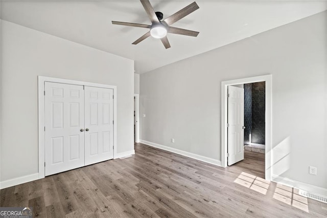 unfurnished bedroom with ceiling fan, a closet, and light wood-type flooring