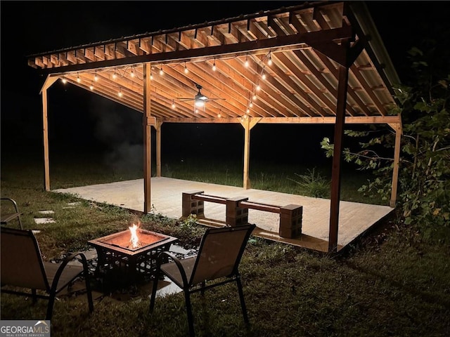 patio at night featuring an outdoor fire pit