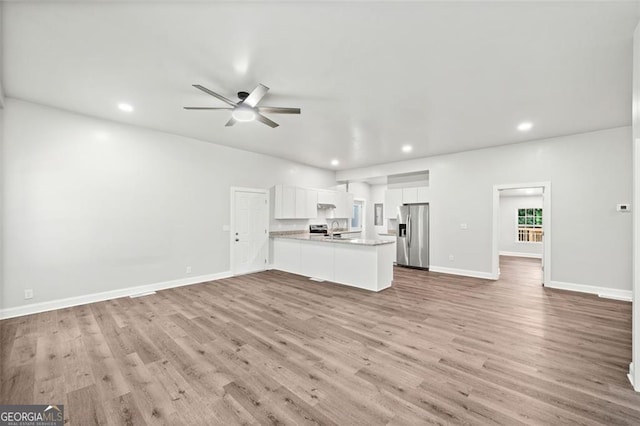 unfurnished living room with ceiling fan and light hardwood / wood-style floors